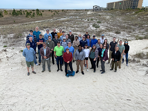 Participants and instructors in the Science of Oil Spills (SOS) class gathered on a beach for a photo in Mobile, Alabama.