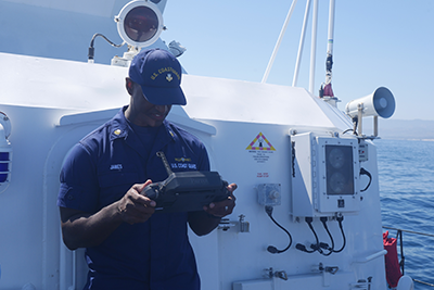 U.S. Coast Guard drone pilots operating a commercial drone controller from the Coast Guard Cutter Blackfin. 
