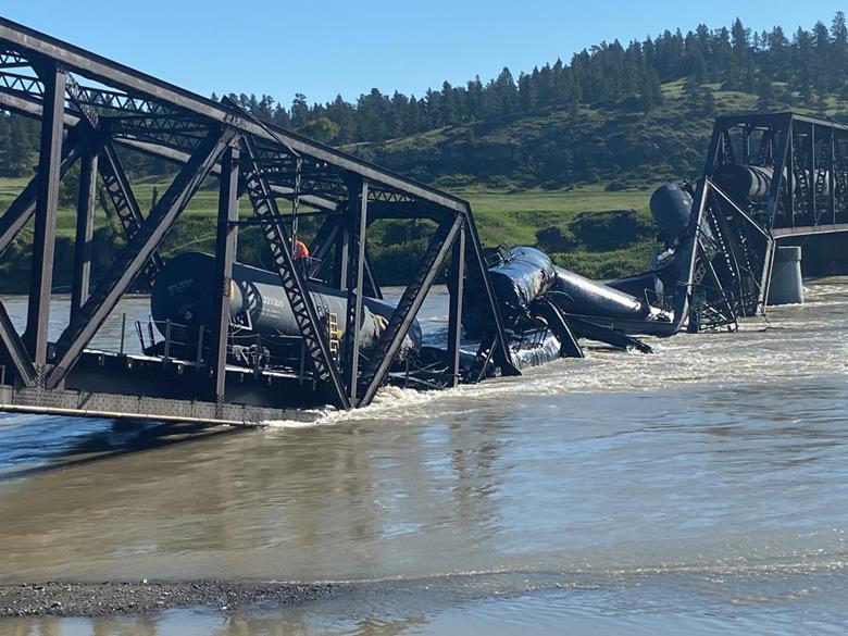 A derailed train in Reed Point, MT with rail cars carrying molten sulfur and molten asphalt sent into the Yellowstone River.