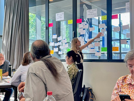 Individual reviews post-its plastered on wall during a collaborative planning activity.