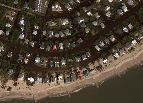 Aerial photo of coastline with houses.