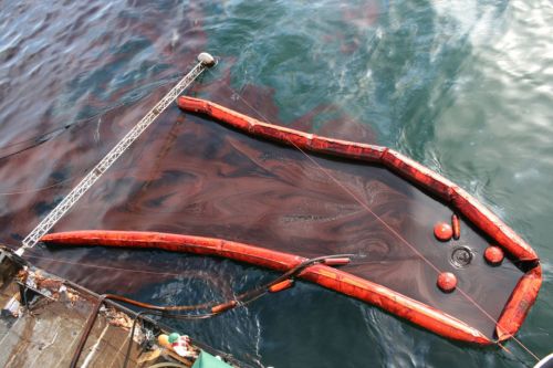 Close up of skimming device on side of a boat with oil and boom. Image Credit: U