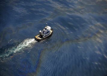 Aerial view of a tug boat crossing oil sheen.