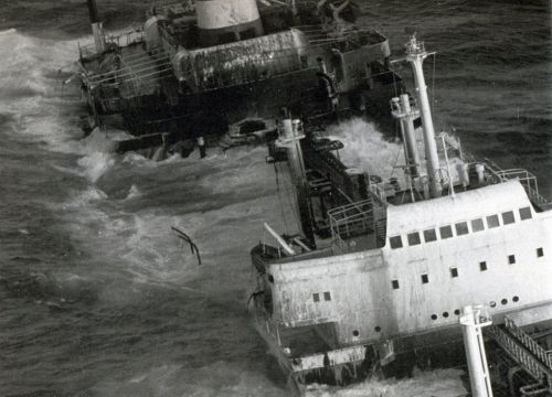 Black and white photo of ship sinking in ocean.