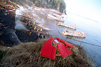 Photo: Navy ships offshore and high-pressure washing of rocky beach.