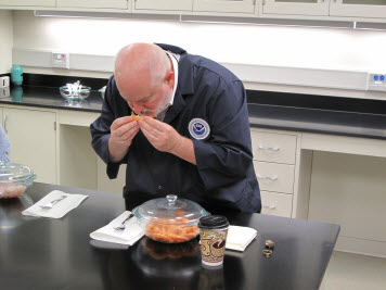 A NOAA seafood tester examines shrimp as part of a sensory test.