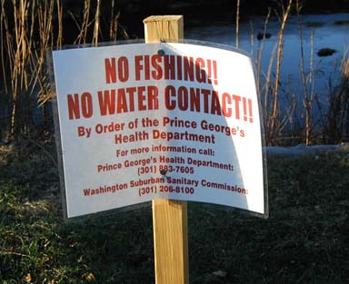 Photo: A sign warning the public not to have contact with the river.