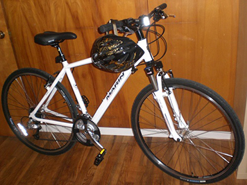 A white bicycle with a helmet.