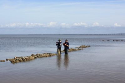 Two people standing in water.