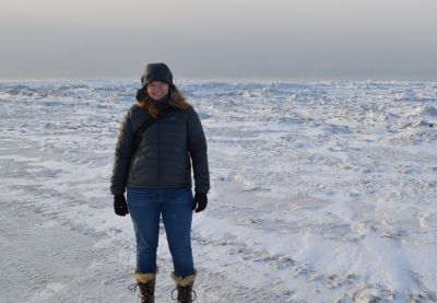 A woman standing on a snowy landscape.