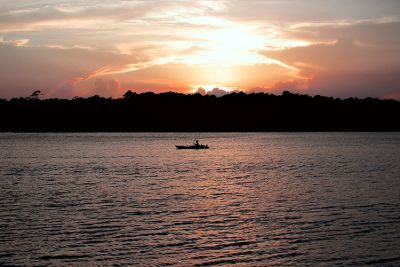 A kayaker on the water at sunset.