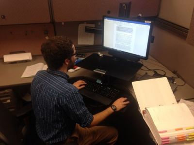 Man sitting at desk with computer. NOAA.