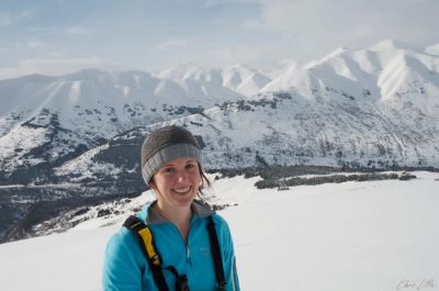 A woman with a snowy mountain scene behind her.