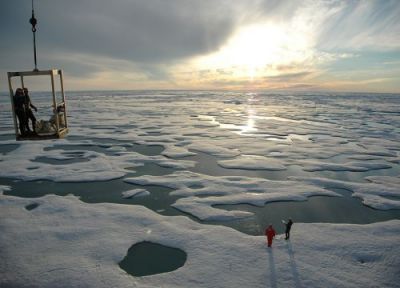 Frozen seascape with two individuals standing on ice.