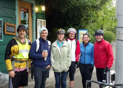 Six people wearing bike helmets standing next to bikes.