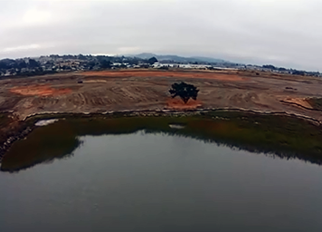 Aerial view of marsh construction site, with berm separating it from the bay.