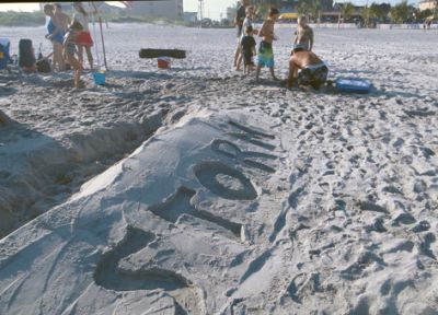 Storm written in sand by sand castle on New Jersey shore.