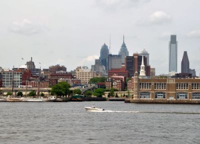 A small boat on the Delaware River with Philadelphia's skyline in the background