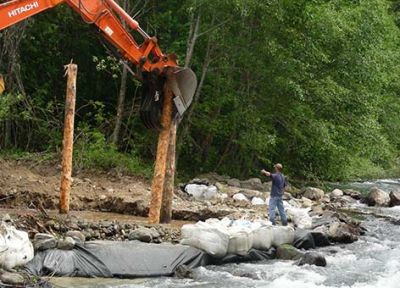 Crews place large wood material which will become engineered log jam habitat for