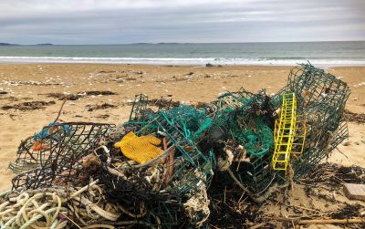 A tangled pile of derelict fishing gear on the shoreline.