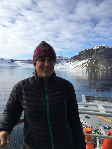 Amy Merten on boat with Arctic ice in background. Image credit: NOAA.