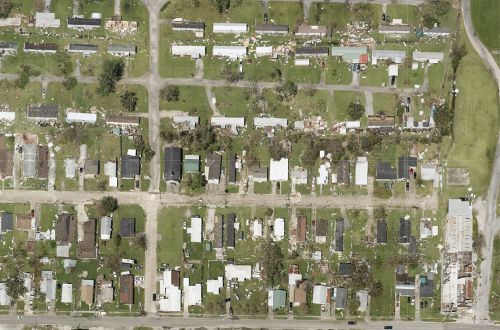 Aerial image of a housing area with hurricane damage and debris.