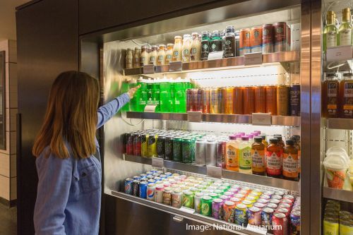 Woman reaching for beverage from case. National Aquarium.