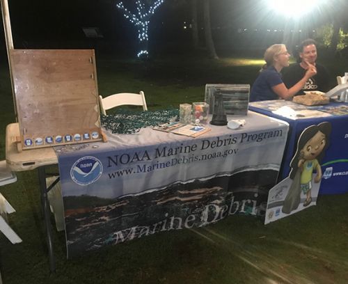 A table with a "Marine Debris Program" poster and a plinko board.