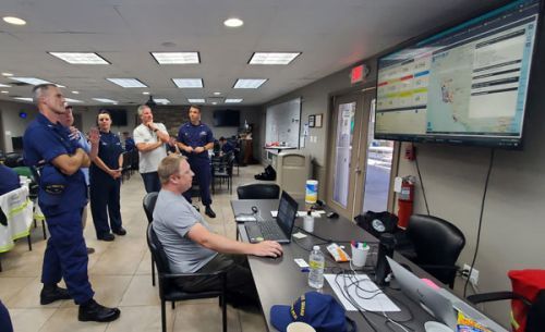 A group of people looking at a screen.