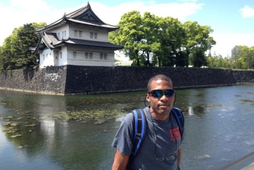 A person posing for a photo in front of a building.