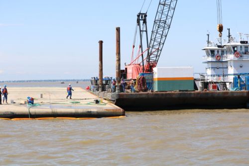 Workers on barges on the water.