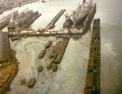 Ships in drydock; oil slicks all around dock area. 