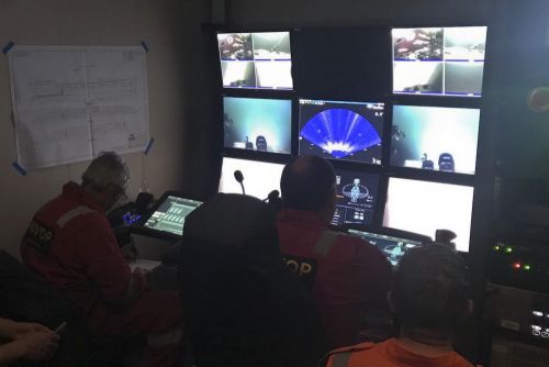 Inside of a control room with several screens with underwater images.