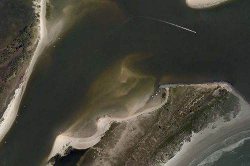 An aerial image of a flooded landscape with boats in the water.