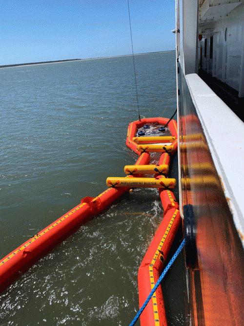 Pollution boom around a vessel.