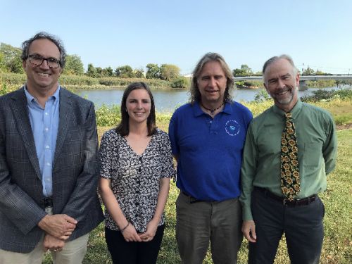 Four people posing on a waterfront