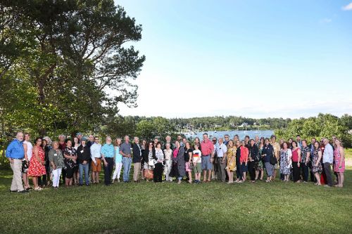 Large group posing for photo on a lawn.