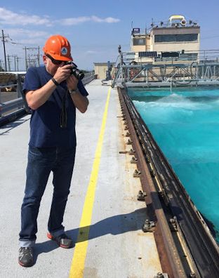 Man taking a photo from a dock.