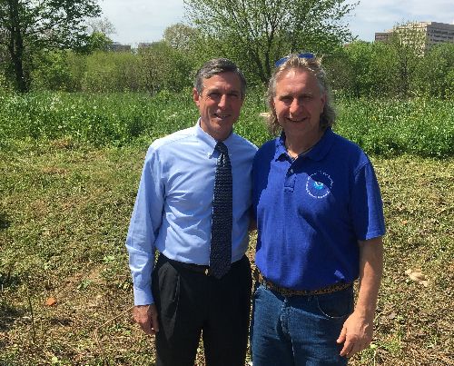 Two men standing in a field.