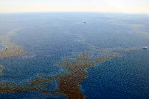 Two boats skimming oil over a large body of water.