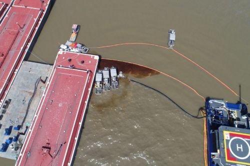 Overhead view of  docks and bow of ship with oil in the water. 