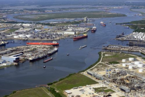 Overview of a channel, with a large tank farm and large vessels.