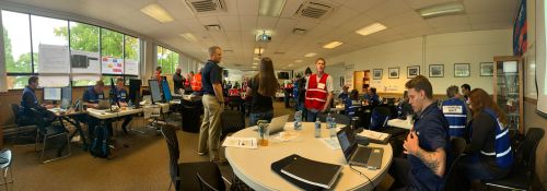 A conference/classroom environment with groups of people at tables.