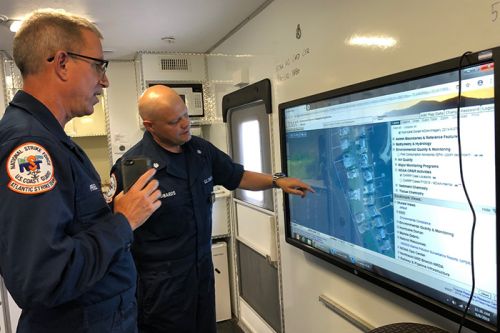 Two people looking at a screen with a map on it.