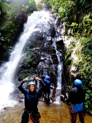 A group of people in front of a waterfall. 