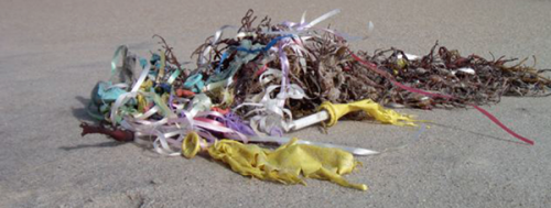 Deflated balloons laying on the beach.