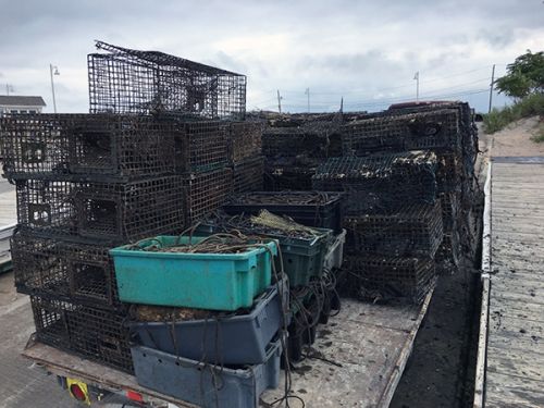 Stacked crab traps and containers.