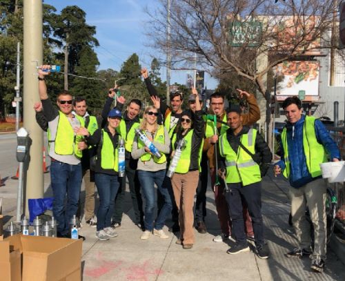 Group of people in matching green vests outdoors.