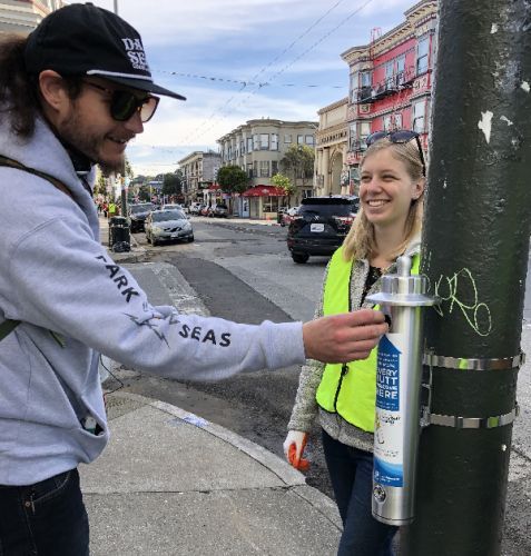 Man installing canister to a pole.