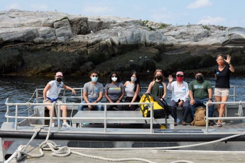 Group of people posing for photo on a dock.